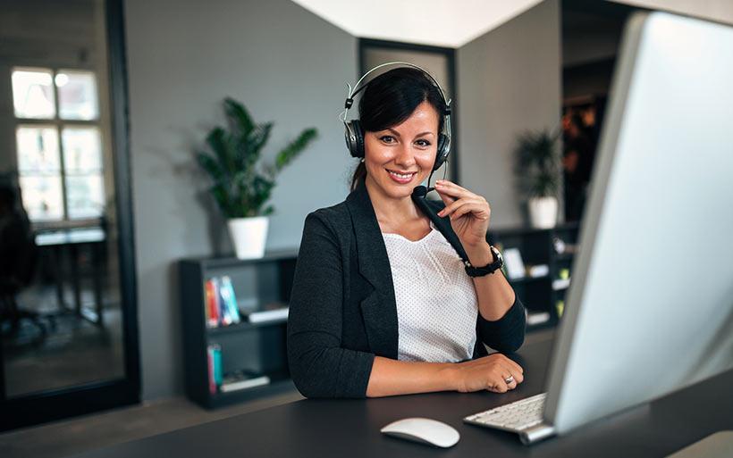 Woman with headset on using live chat software for a medical practice.