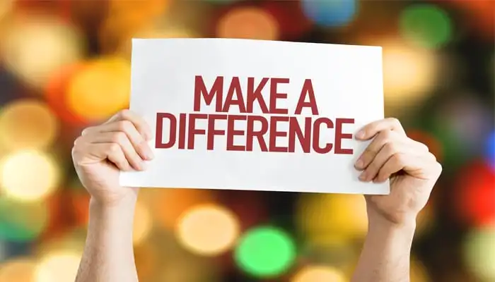 person holds a sign that says "make a difference"