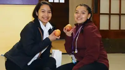 Cristo Rey Kansas City students show off the apples they received as part of the Apple a Day program.