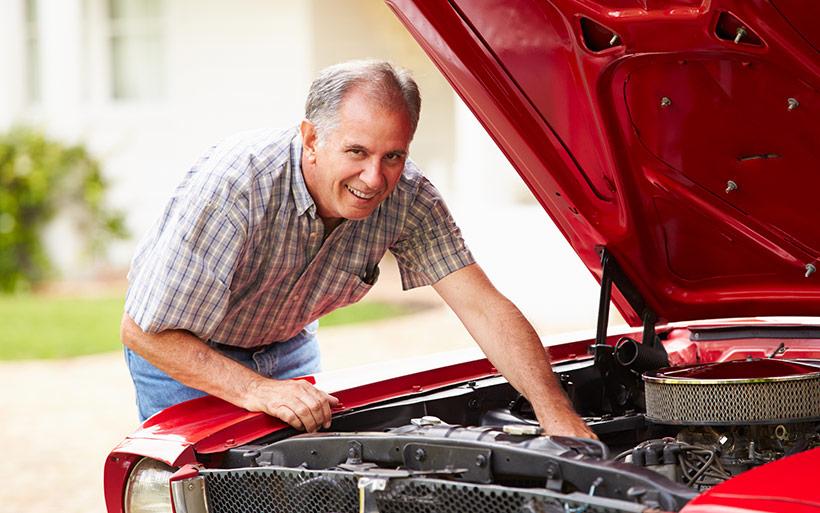 Man under the hood working on a car.