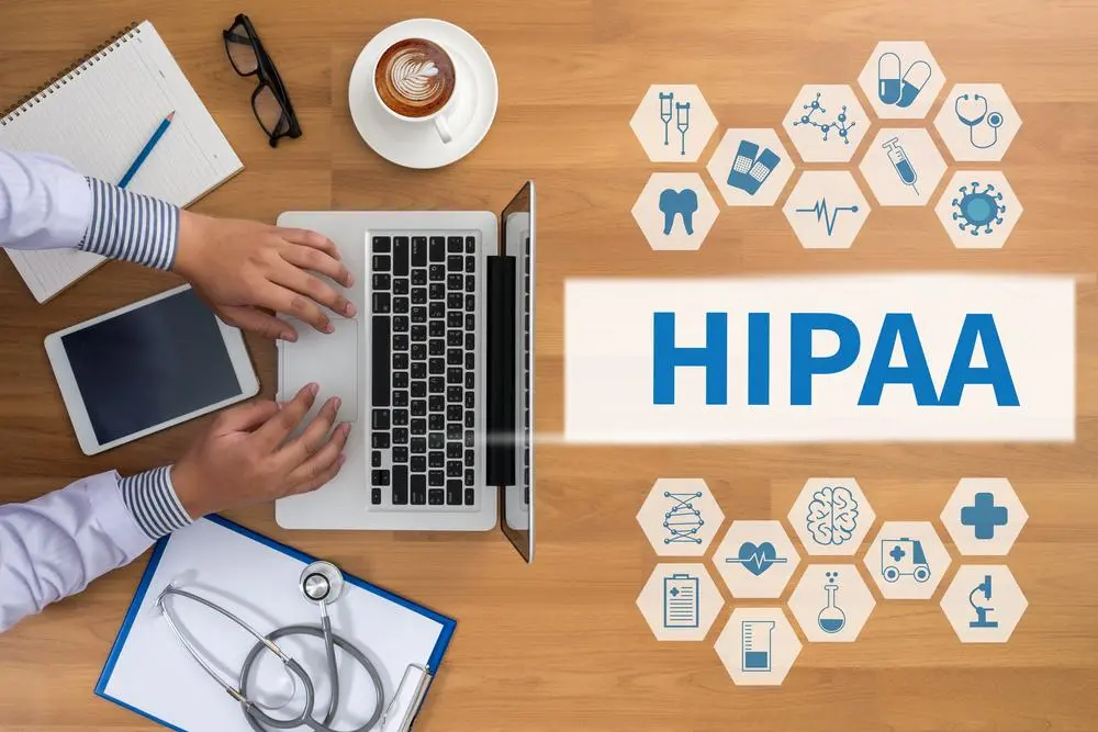 HIPAA graphic and person on laptop