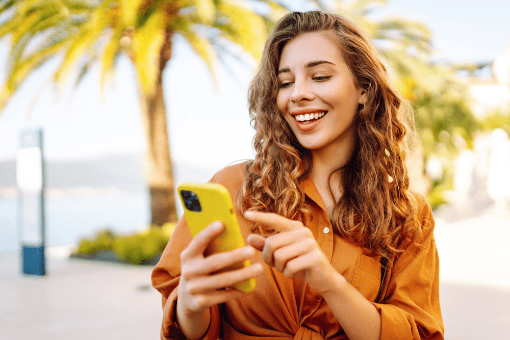 young woman looking at audiology website on her phone