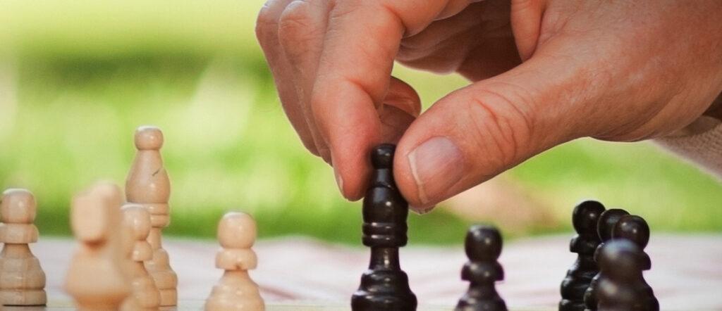 Image of a hand playing chess