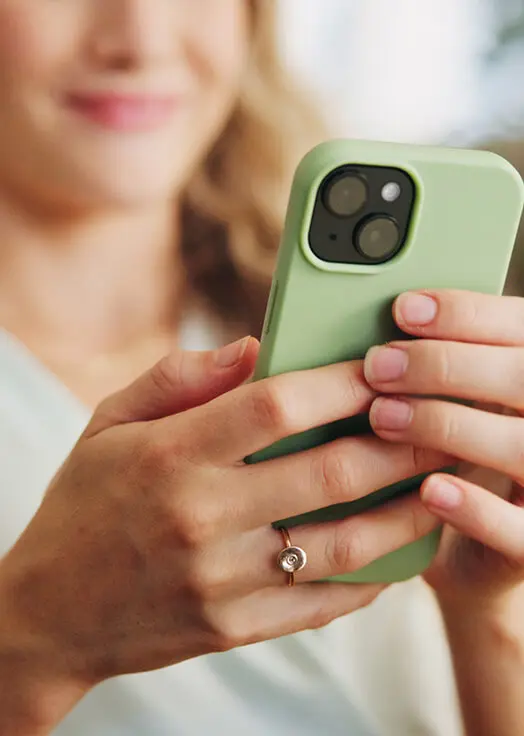 woman's hands holding smartphone with her face blurred in the background