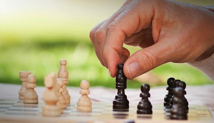 hand moving piece on chess board