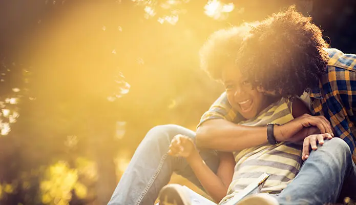 African American father and daughter playing in park.