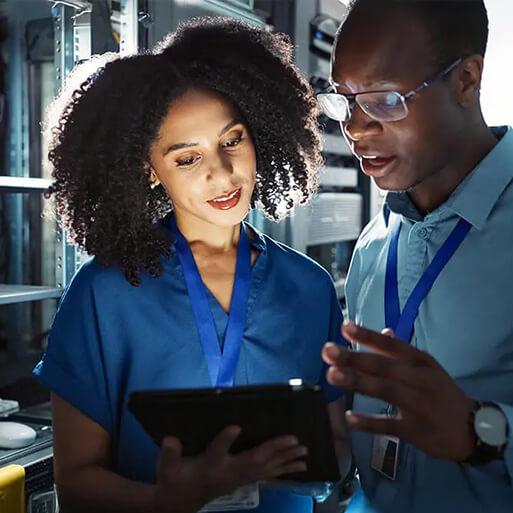 man and woman talking and looking at tablet