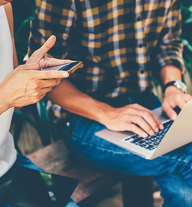 Young business people using laptop and phone