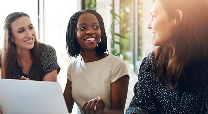 Business women, conversation and laptop data with planning and strategy in office.