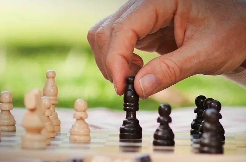 hand moving piece on chess board