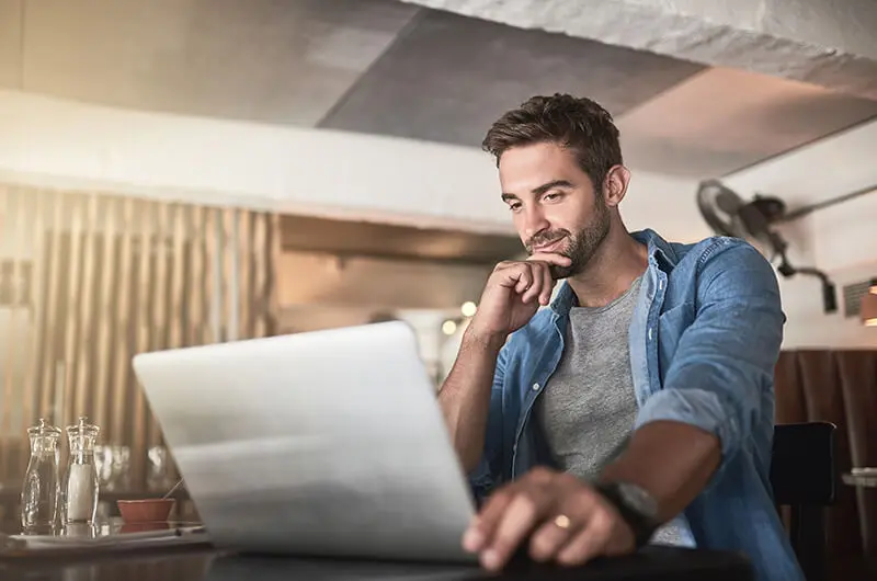 man working on a laptop in a coffee shop