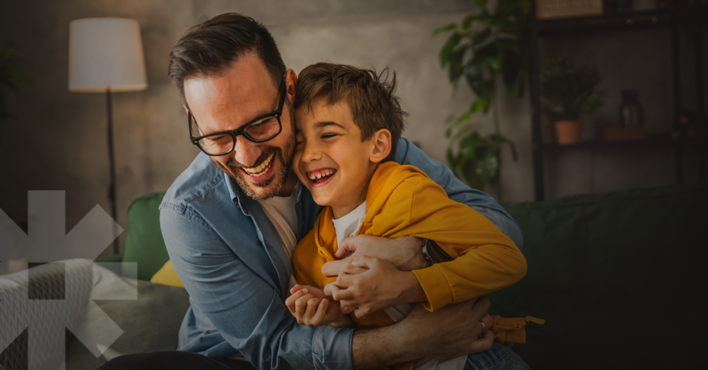 A father and son share a joyful embrace, representing the trust and connection that a ‘strategy first’ approach fosters in successful hospital marketing.