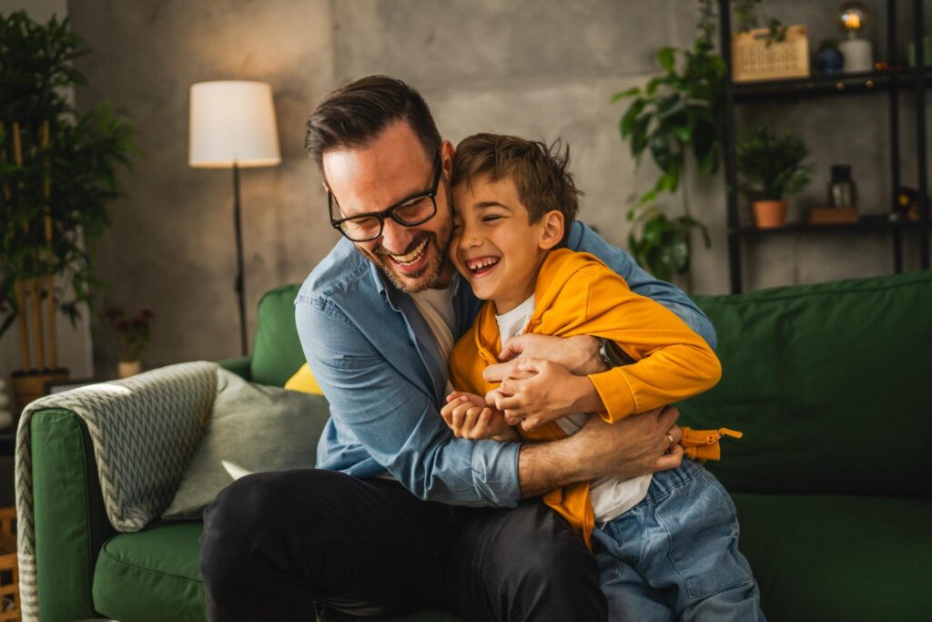 A father and son share a joyful embrace, representing the trust and connection that a ‘strategy first’ approach fosters in successful hospital marketing.
