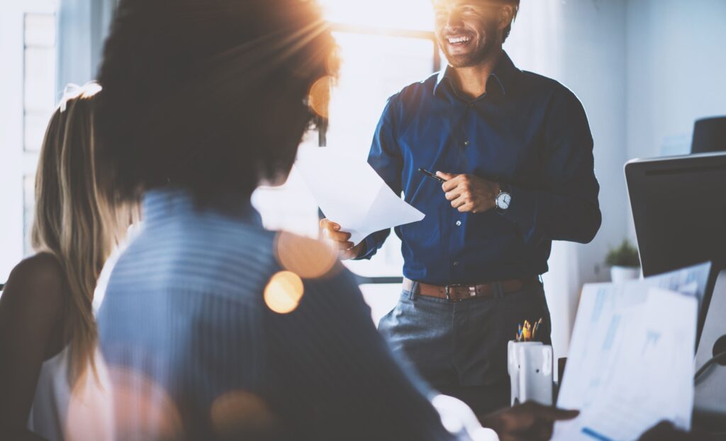 A sunlit photo of a healthcare marketing team collaborating among their specialized teams and team members.
