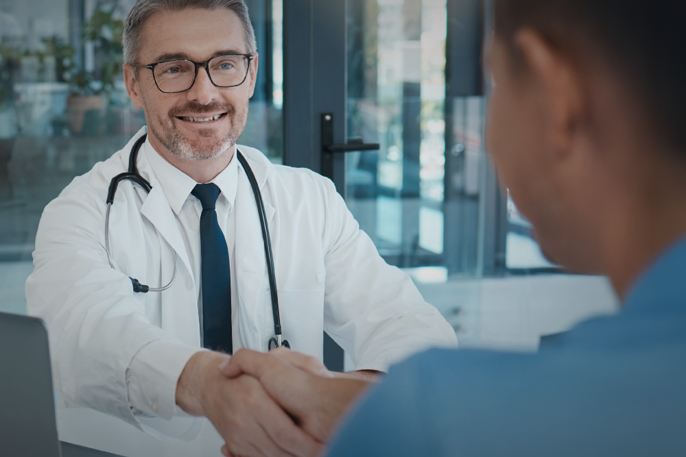 A urologist in a white coat consults with a male patient.