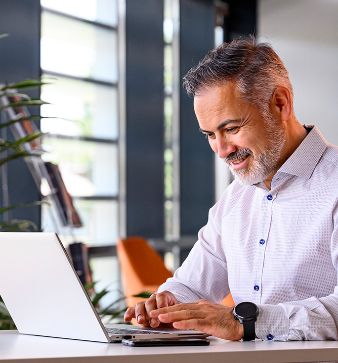 man working on a laptop computer seated at a desk