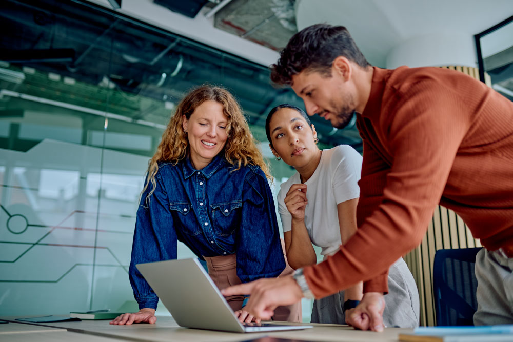 three business people looking at a laptop