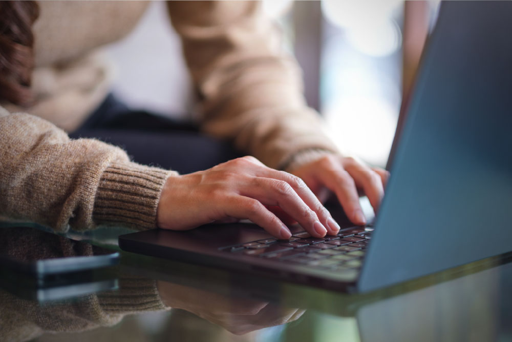 Person using a laptop to research healthcare information, representing AI-powered search and digital visibility.